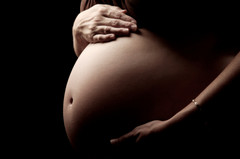 Gravid kvinne som holder på magen sin