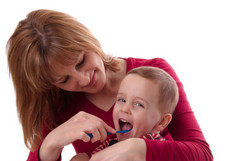 Mamma pusser tennene på barnet sitt