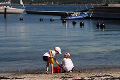 To barn leter etter skjell på stranden
