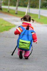 Lite barn med barnehagesekk som alene er på vei til barnehagen