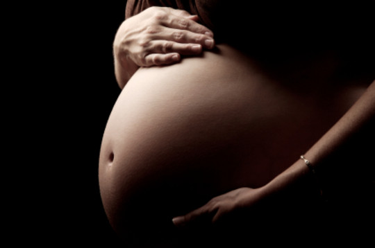 Gravid kvinne som holder p�� magen sin