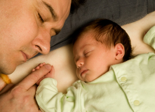 Pappa sover med babyen sin mens de holder i h��nden