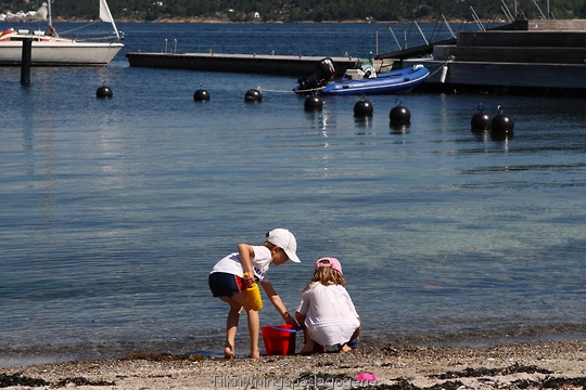 To barn leter etter skjell p�� stranden